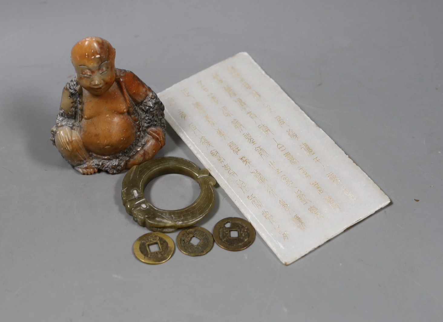 Assorted Chinese items to include a jade ring, coins, a stone inscribed plaque, 15.8 x 8cm and a soapstone figure
